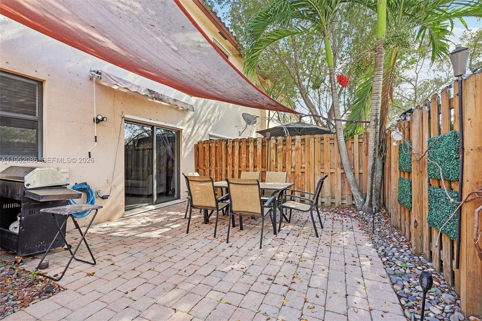 11746 Southwest 151 Avenue Miami, FL 33196 - Photo 35 of 37 a view of a patio with table and chairs and potted plants