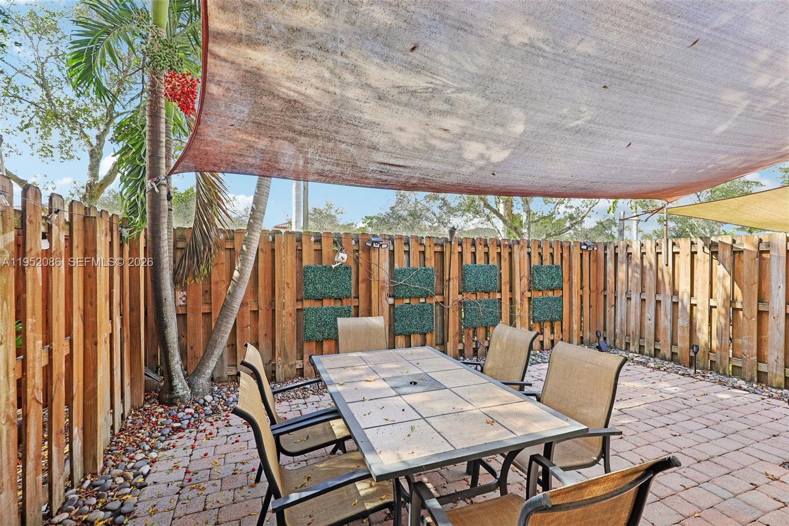 11746 Southwest 151 Avenue Miami, FL 33196 - Photo 36 of 37 a view of a patio with a table chairs and a backyard