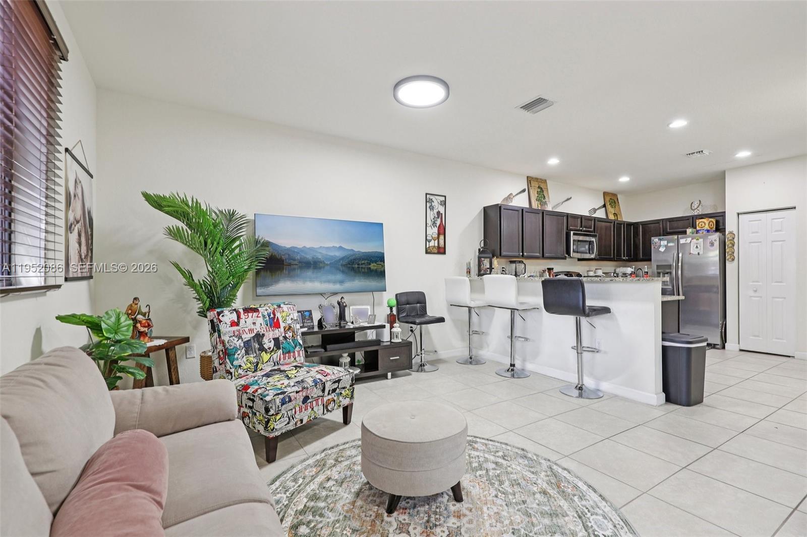 11746 Southwest 151 Avenue Miami, FL 33196 - Photo 6 of 37 a living room with furniture and kitchen view