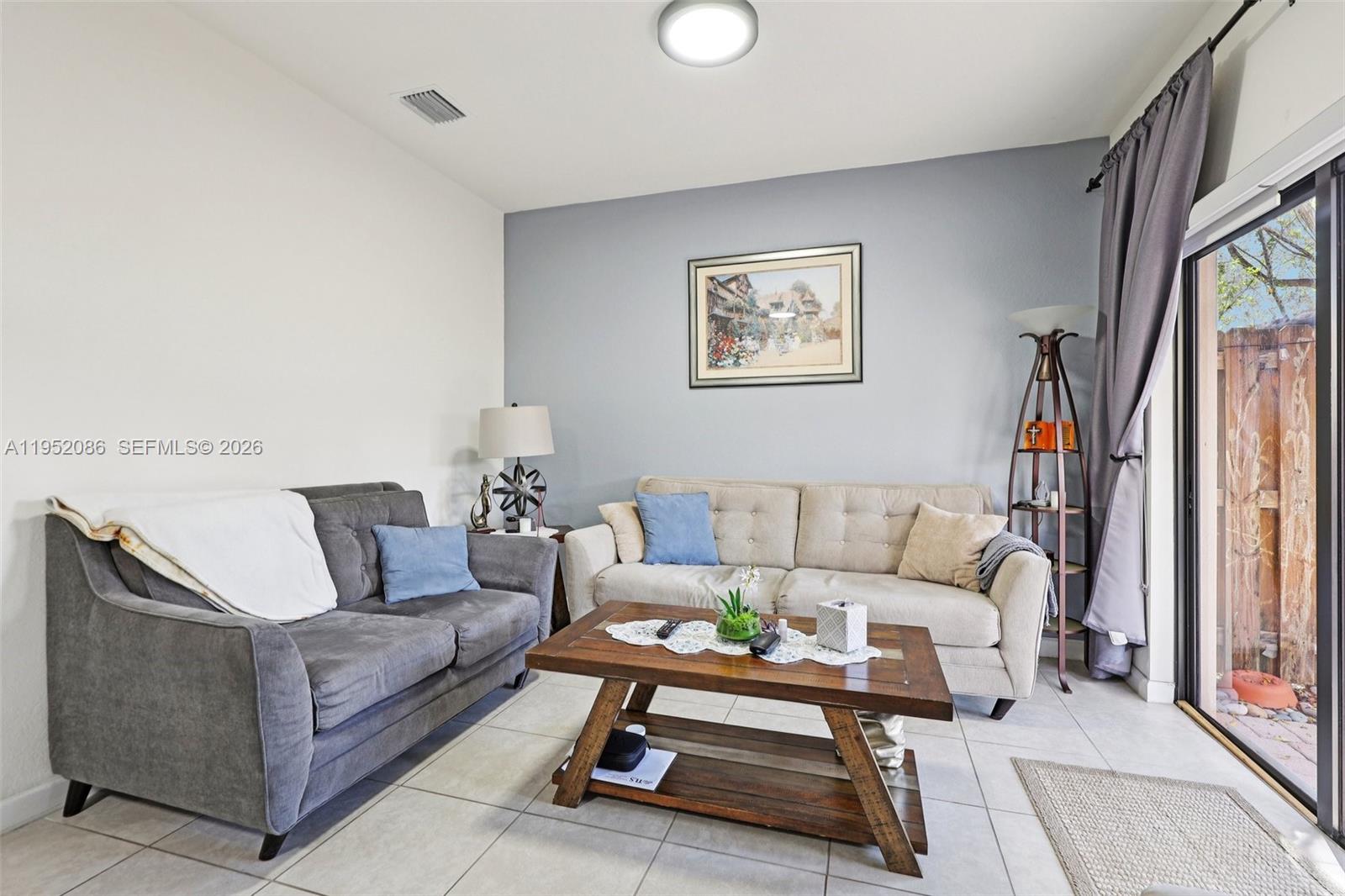 11746 Southwest 151 Avenue Miami, FL 33196 - Photo 8 of 37 a living room with furniture a rug and a table