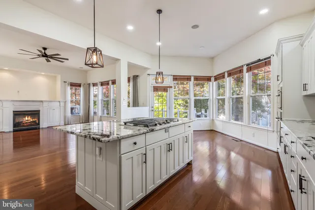a kitchen with kitchen island a stove a sink and a wooden floors