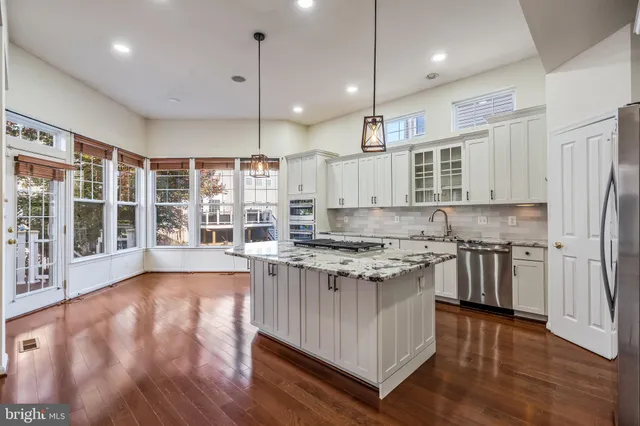 a kitchen with stainless steel appliances granite countertop a refrigerator and a sink