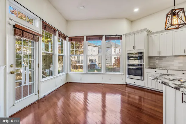 a kitchen with stainless steel appliances kitchen island wooden floors wooden cabinets a stove and a center island