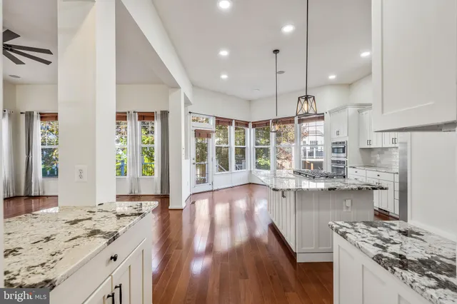 a open kitchen with kitchen island a large island in the center and stainless steel appliances