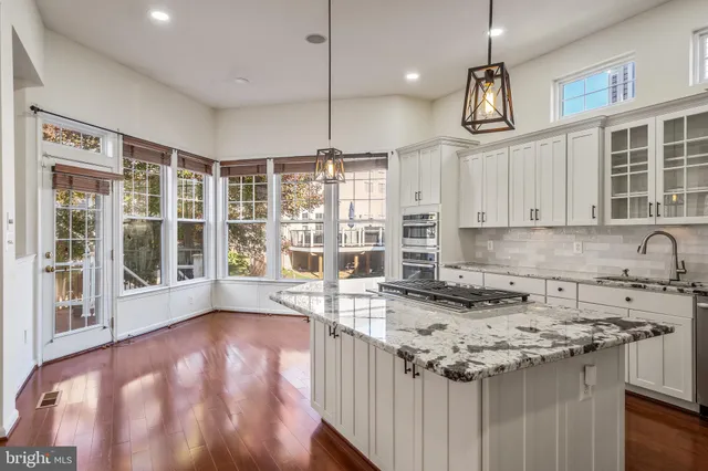 a kitchen with granite countertop a sink a counter top space and cabinets