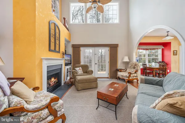 a kitchen with stainless steel appliances kitchen island granite countertop a refrigerator a stove a sink a dining table and chairs with wooden floor