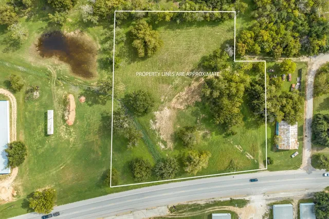 a view of a field with trees in the background
