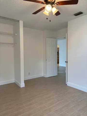a view of an empty room with a chandelier fan