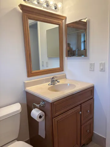 a bathroom with a toilet sink and mirror