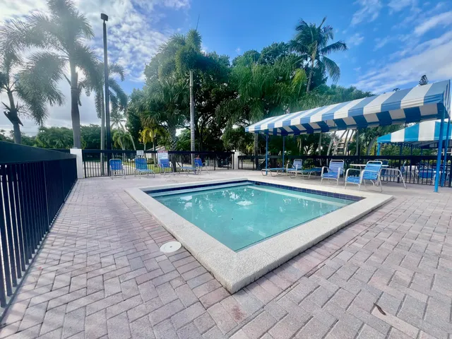 a view of a swimming pool with a yard and plants