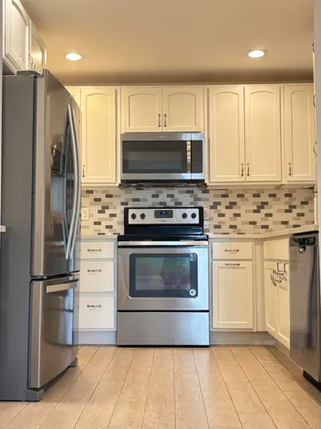 a kitchen with stainless steel appliances a stove a sink and a refrigerator