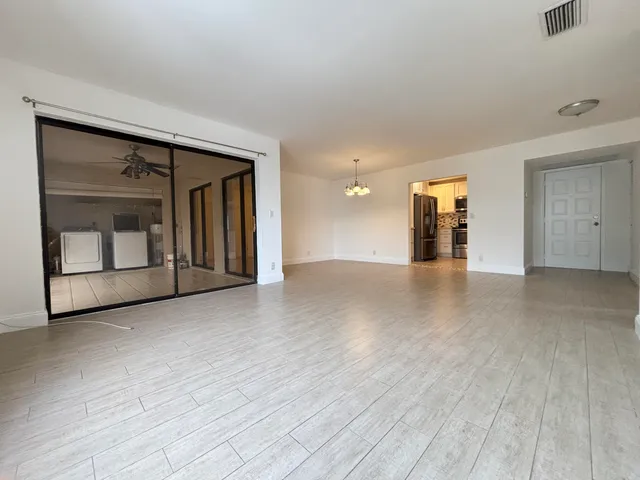 a view of a livingroom with wooden floor and a ceiling fan
