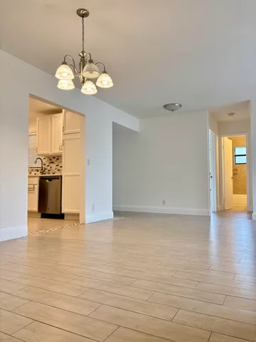a view of a kitchen with a stove kitchen island wooden cabinets and wooden floor