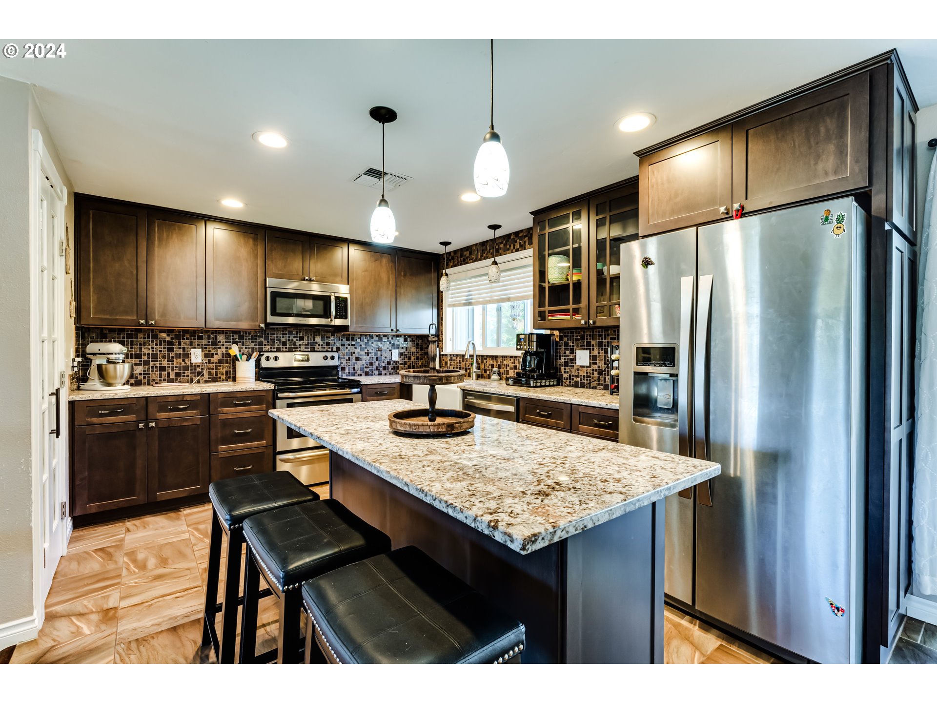 2288 9th Street Springfield, OR 97477 - Photo 11 of 41 a kitchen with kitchen island a refrigerator a stove a sink a stove a dining table and chairs