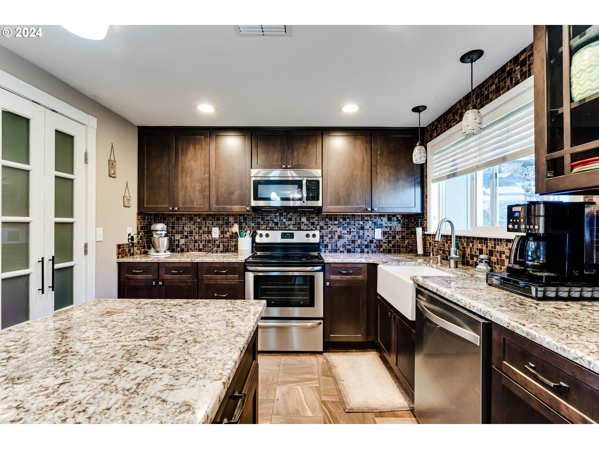 2288 9th Street Springfield, OR 97477 - Photo 14 of 41 a kitchen with stainless steel appliances kitchen island granite countertop a stove sink and cabinets