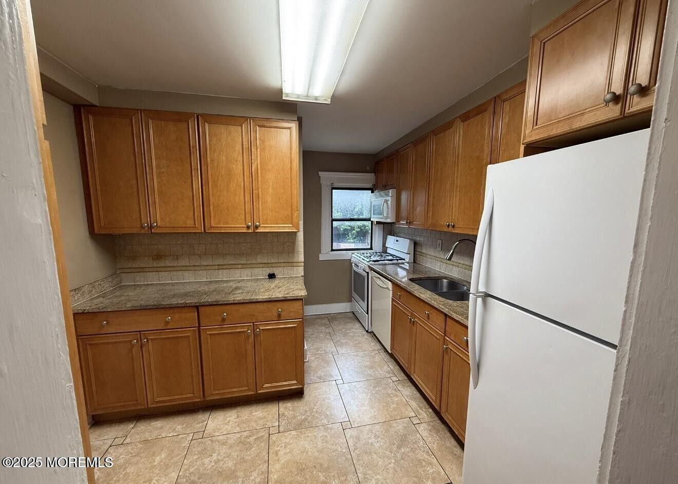 1001 Norwood Avenue, Unit 4 Long Branch, NJ 07740 - Photo 5 of 9 a kitchen with a refrigerator a stove top oven and cabinets