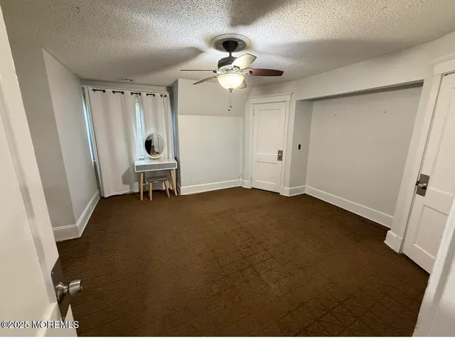 an empty room with a fan and a window