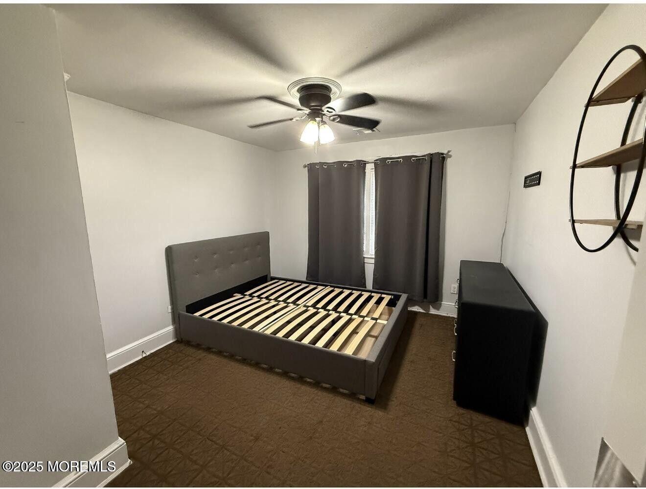 1001 Norwood Avenue, Unit 4 Long Branch, NJ 07740 - Photo 8 of 9 a bedroom with a bed and a chandelier