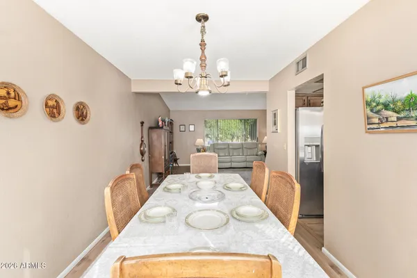 a view of a dining room with furniture a chandelier and wooden floor