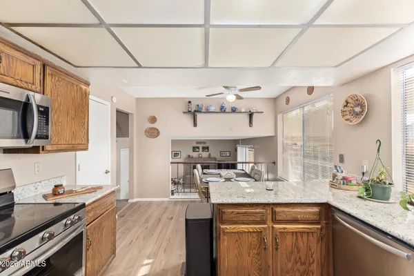 a kitchen with granite countertop a sink cabinets and stainless steel appliances