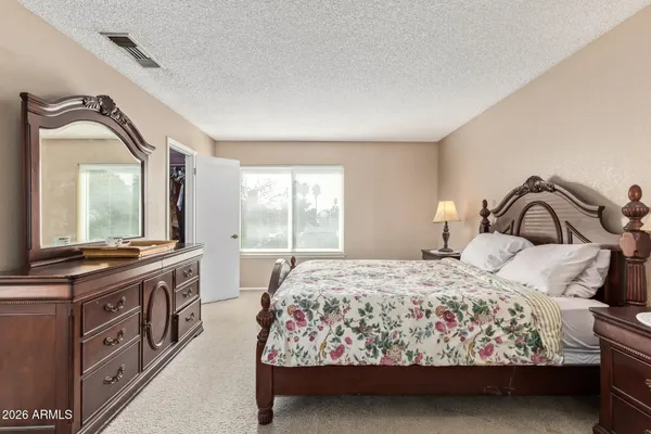 a bedroom with a bed and dresser with mirror