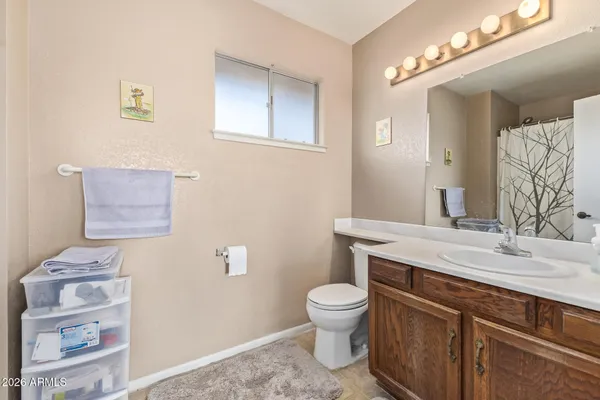 a bathroom with a granite countertop toilet sink and mirror