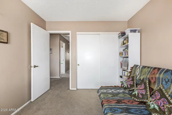 a bedroom with a bed and a painting on the wall