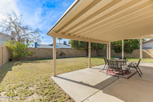 a view of a patio with table and chairs with wooden floor and fence