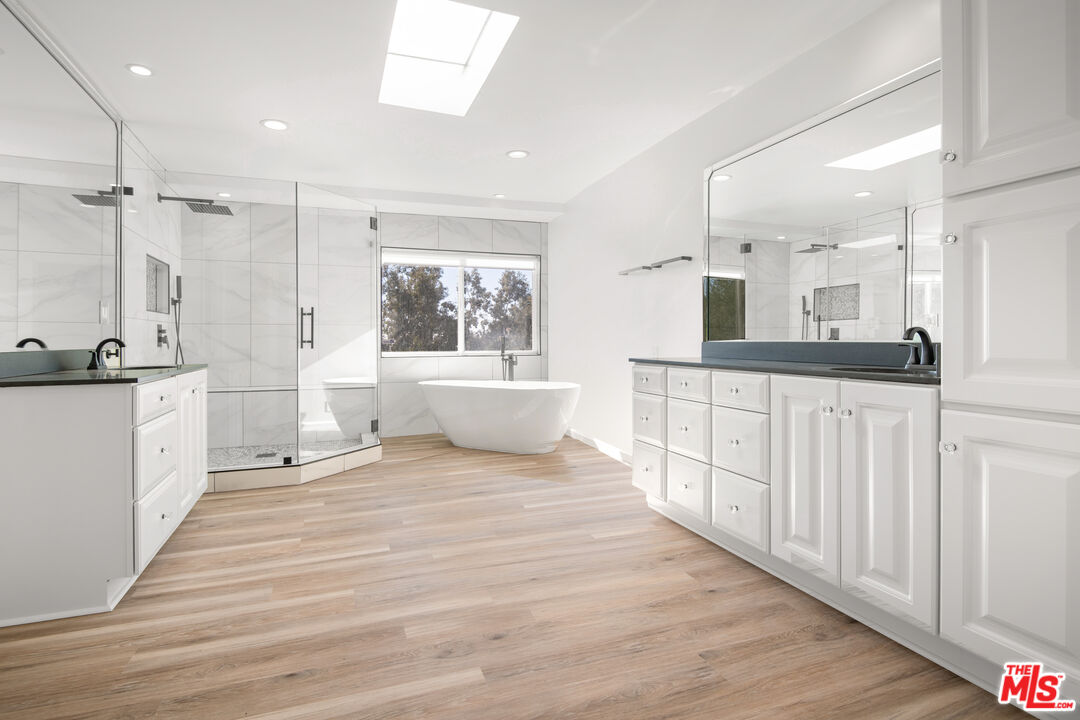 1001 Stradella Road Los Angeles, CA 90077 - Photo 11 of 28 a large white bathroom with a granite countertop sink a toilet a mirror and shower