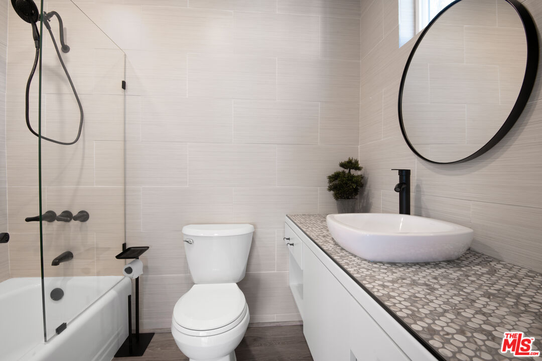 1001 Stradella Road Los Angeles, CA 90077 - Photo 14 of 28 a bathroom with a granite countertop toilet a sink and a mirror