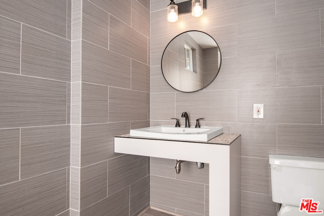 1001 Stradella Road Los Angeles, CA 90077 - Photo 18 of 28 a bathroom with a sink and a mirror
