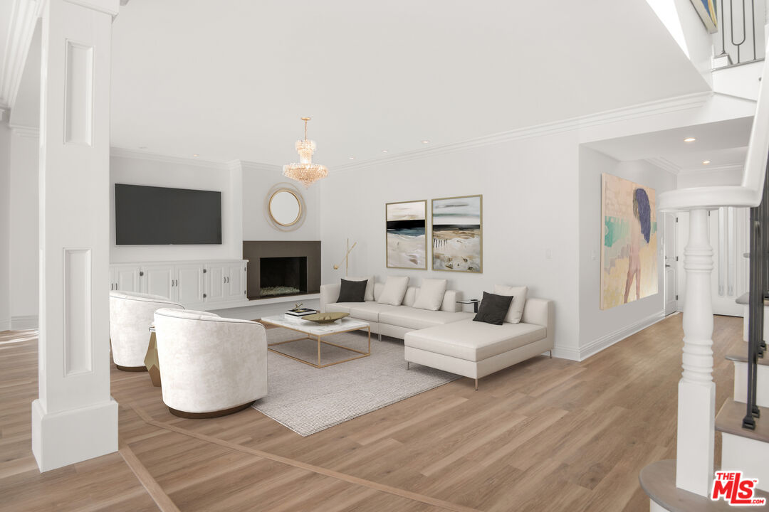 1001 Stradella Road Los Angeles, CA 90077 - Photo 5 of 28 a living room with furniture a fireplace and a flat screen tv
