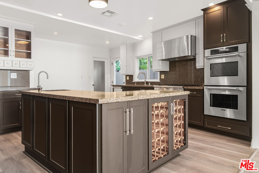 1001 Stradella Road Los Angeles, CA 90077 - Photo 7 of 28 a kitchen with stainless steel appliances granite countertop a sink stove and refrigerator