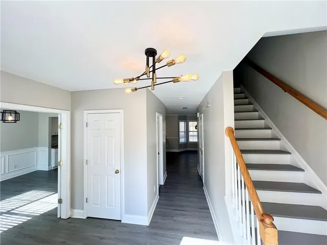 a view of a hallway with wooden floor and entryway