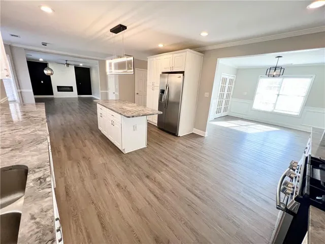 a kitchen with stainless steel appliances a refrigerator and wooden floor