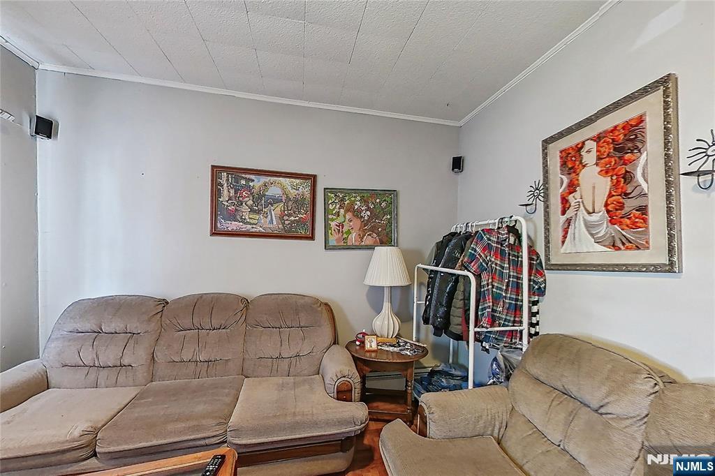 42 Grand Street Garfield, NJ 07026 - Photo 12 of 26 a living room with furniture a couch and paintings on the wall