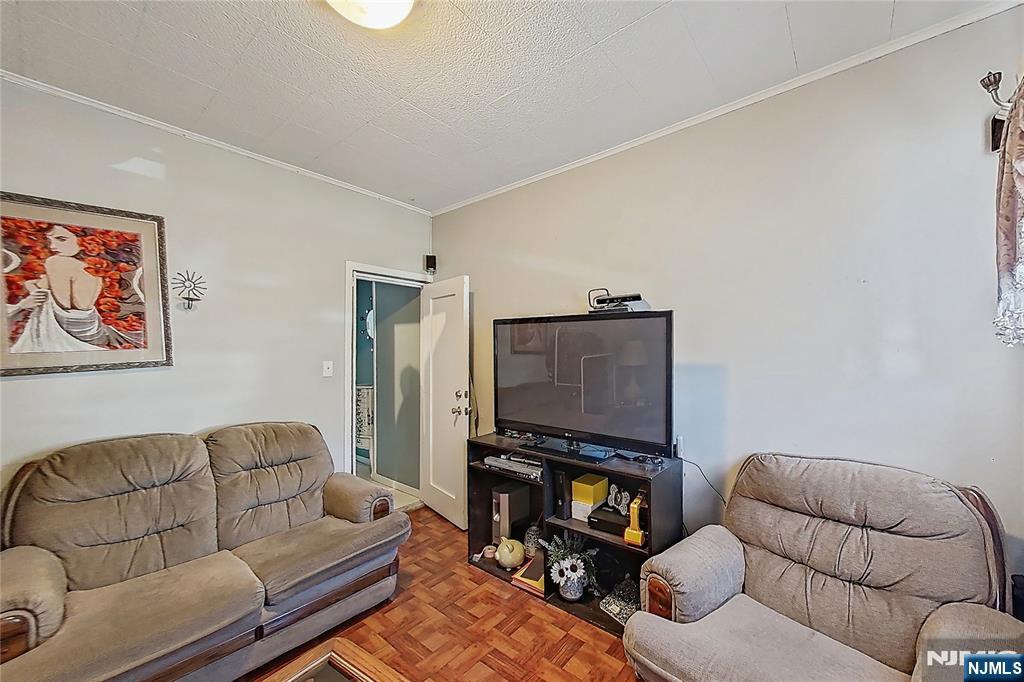 42 Grand Street Garfield, NJ 07026 - Photo 15 of 26 a living room with furniture a couch and a flat screen tv