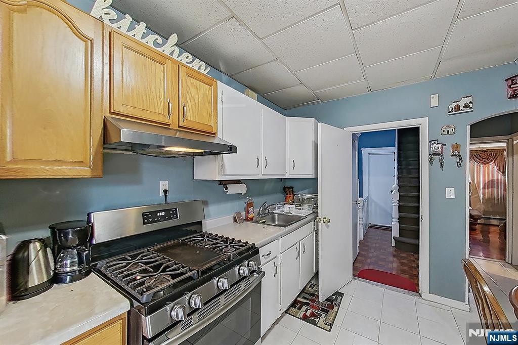42 Grand Street Garfield, NJ 07026 - Photo 17 of 26 a kitchen with stainless steel appliances granite countertop a stove and a refrigerator