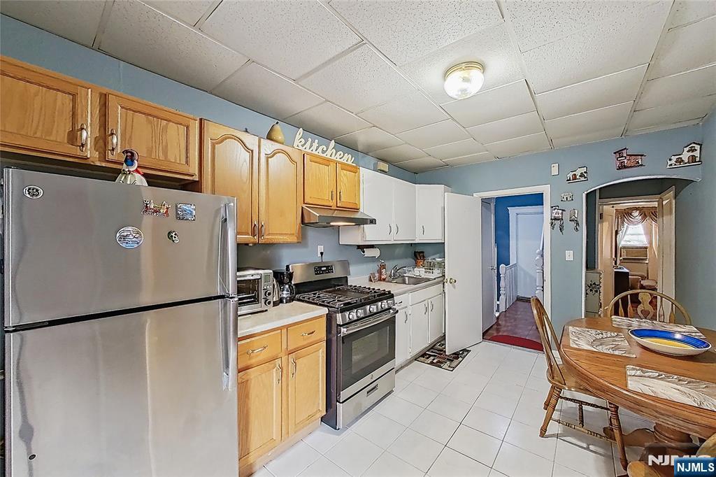 42 Grand Street Garfield, NJ 07026 - Photo 18 of 26 a kitchen with stainless steel appliances granite countertop a refrigerator a stove a sink dishwasher and white cabinets with wooden floor