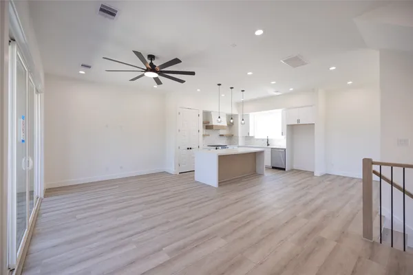 a view of kitchen with granite countertop a stove top oven a sink and white cabinets with wooden floor