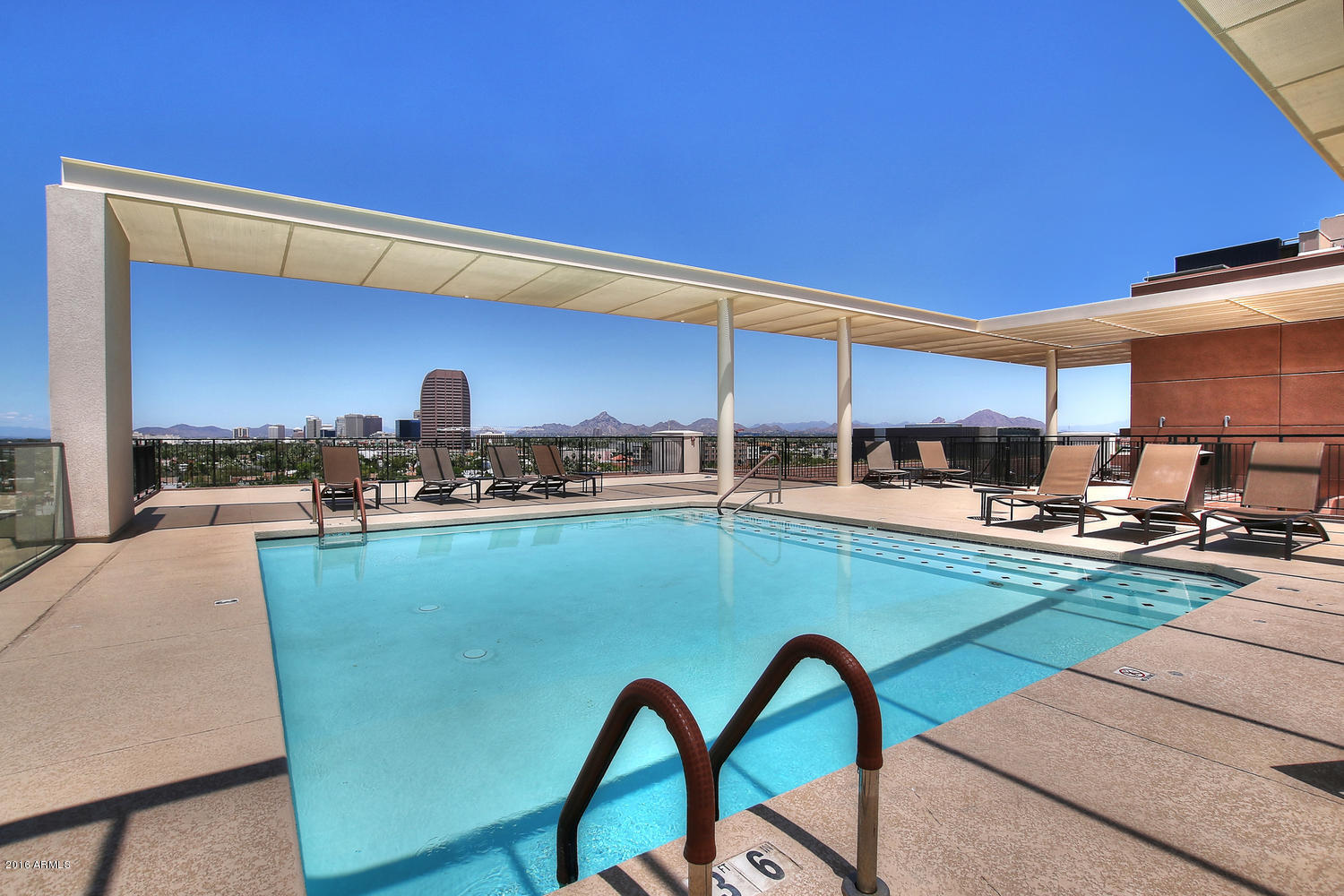 208 West Portland Street, Unit 460 Phoenix, AZ 85003 - Photo 30 of 37 a kitchen with stainless steel appliances a table and chairs in it
