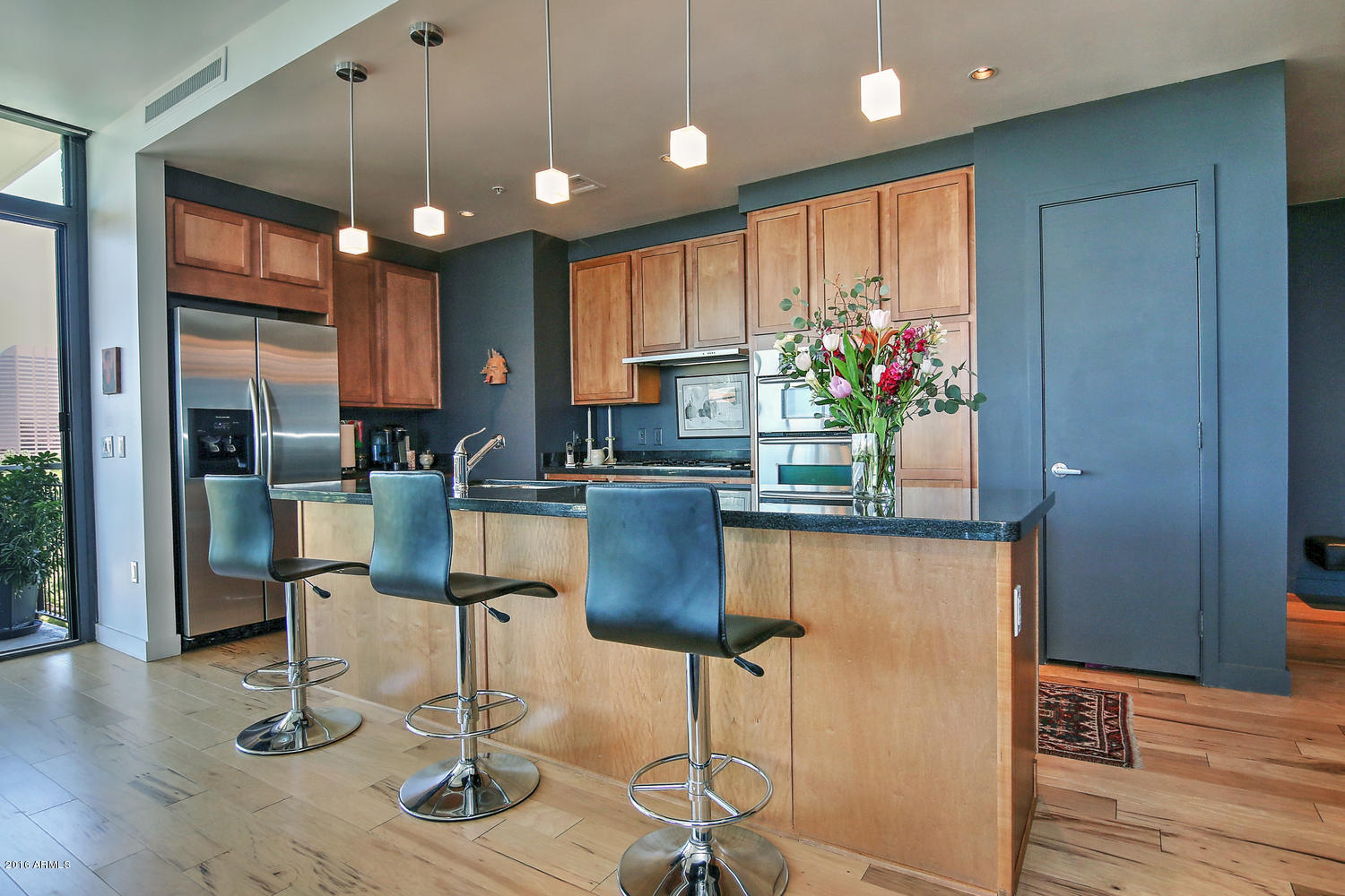 208 West Portland Street, Unit 460 Phoenix, AZ 85003 - Photo 7 of 37 a kitchen with stainless steel appliances granite countertop a refrigerator dining table and chairs