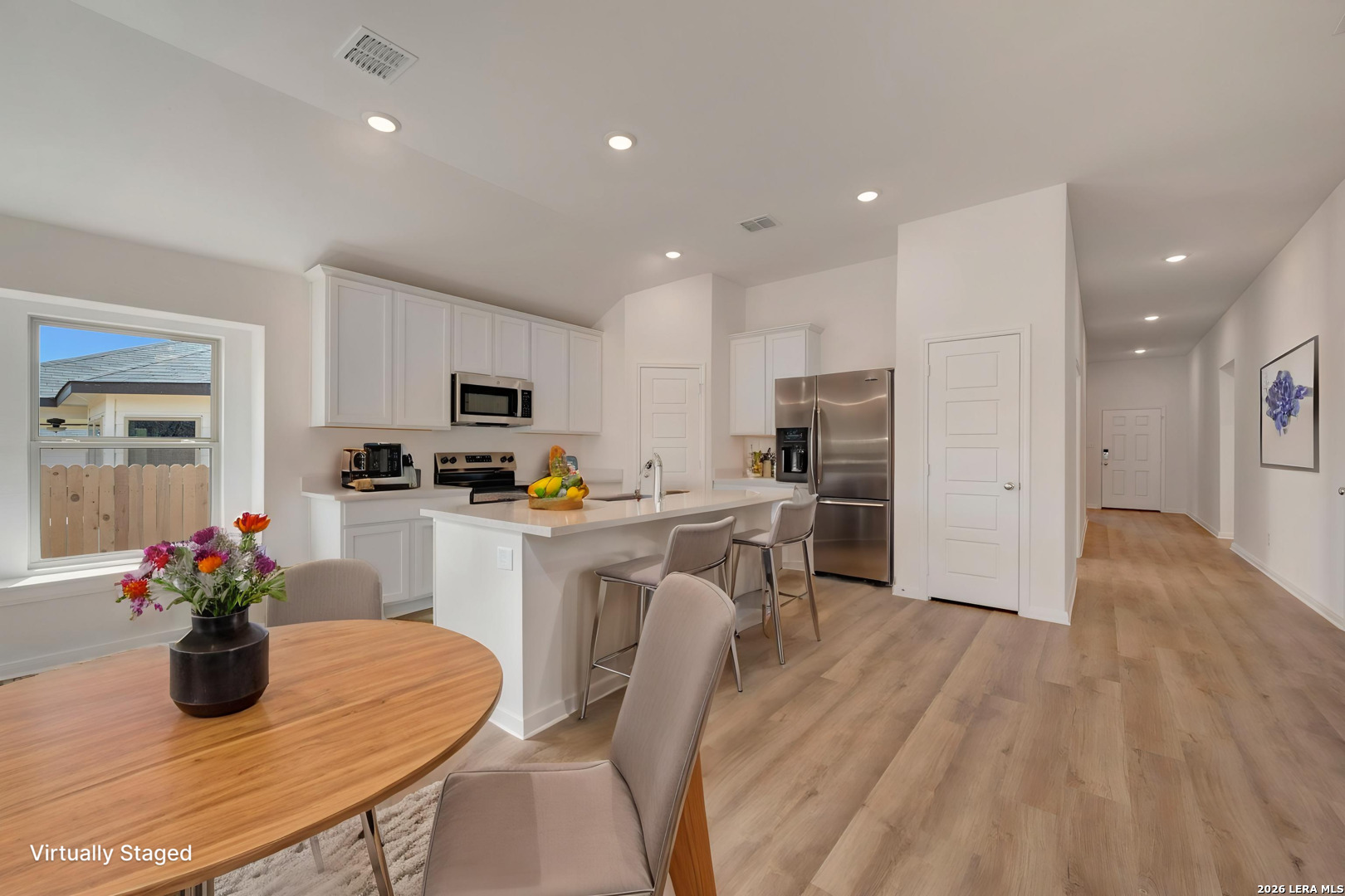 2829 Sun Bayou Seguin, TX 78155 - Photo 2 of 45 a kitchen with white cabinets stainless steel appliances and dining table