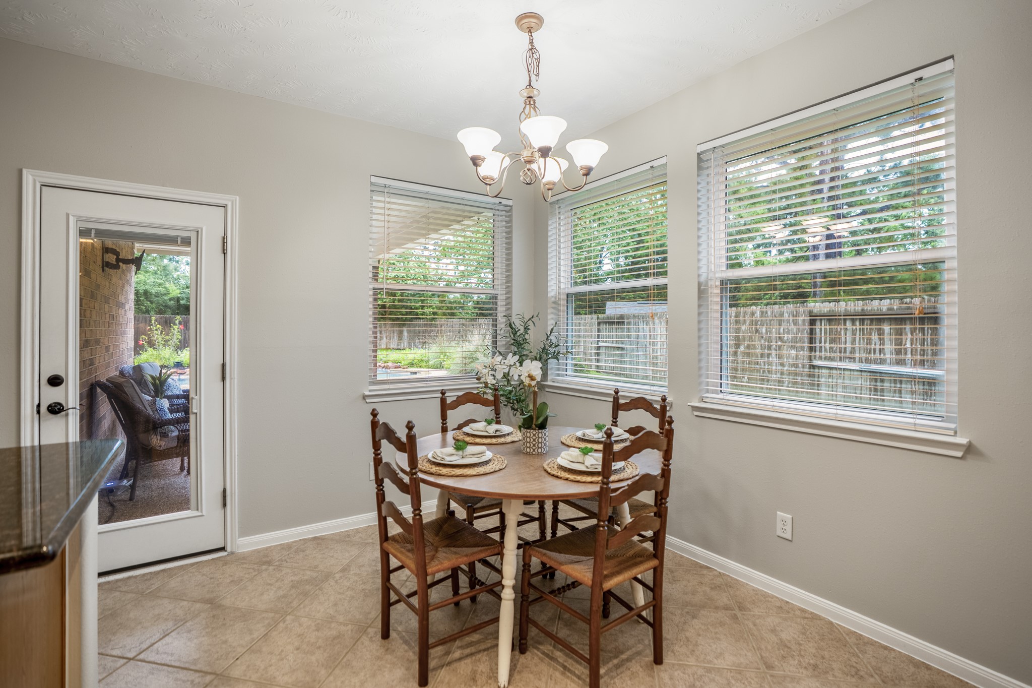 6311 Sparrows Glen Lane Spring, TX 77379 - Photo 11 of 50 Surrounded by windows overlooking the patio and yard, the breakfast area sits just off the kitchen with a direct door to the covered patio—keeping morning coffee, casual meals, and pool-day traffic connected to the outdoor retreat.