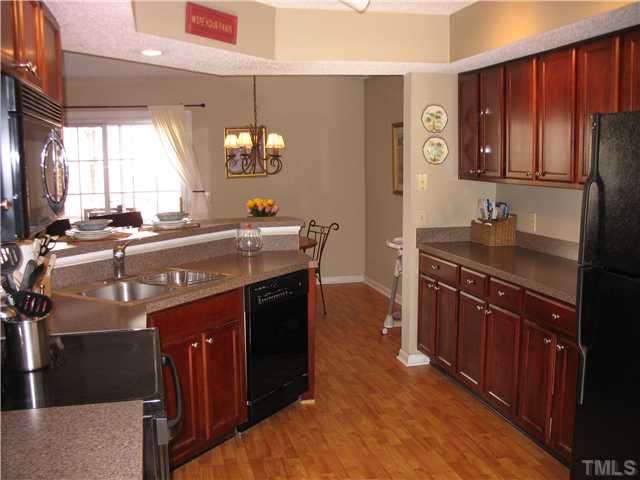 2406 Condor Court Raleigh, NC 27615 - Photo 6 of 16 a kitchen with stainless steel appliances granite countertop a sink a stove and a wooden floors