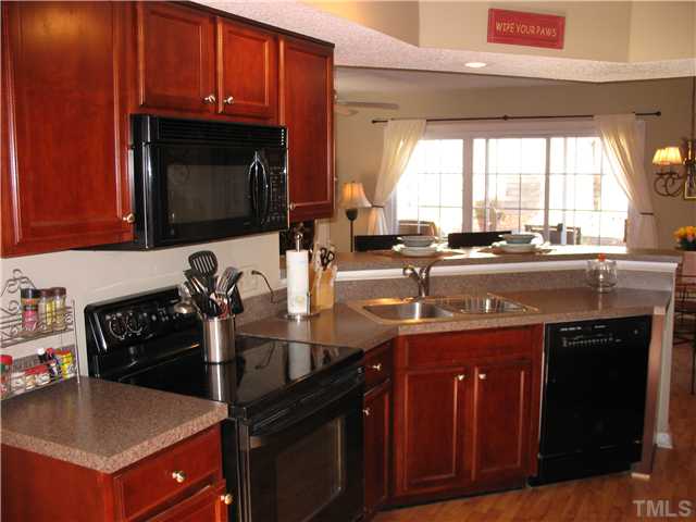 2406 Condor Court Raleigh, NC 27615 - Photo 7 of 16 a kitchen with a stove and a microwave