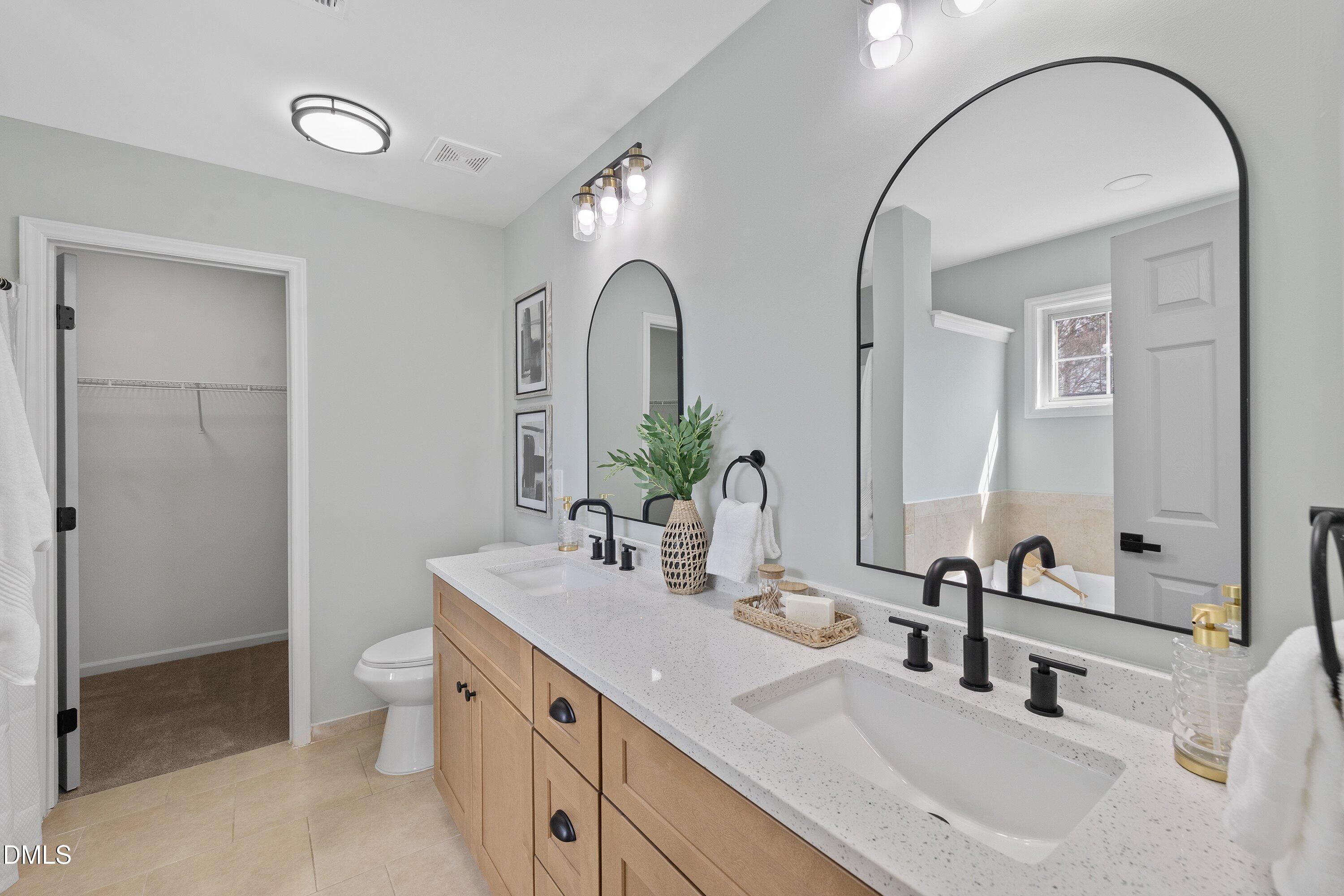 4219 Mantua Way Raleigh, NC 27604 - Photo 7 of 44 a bathroom with a double vanity sink and a mirror