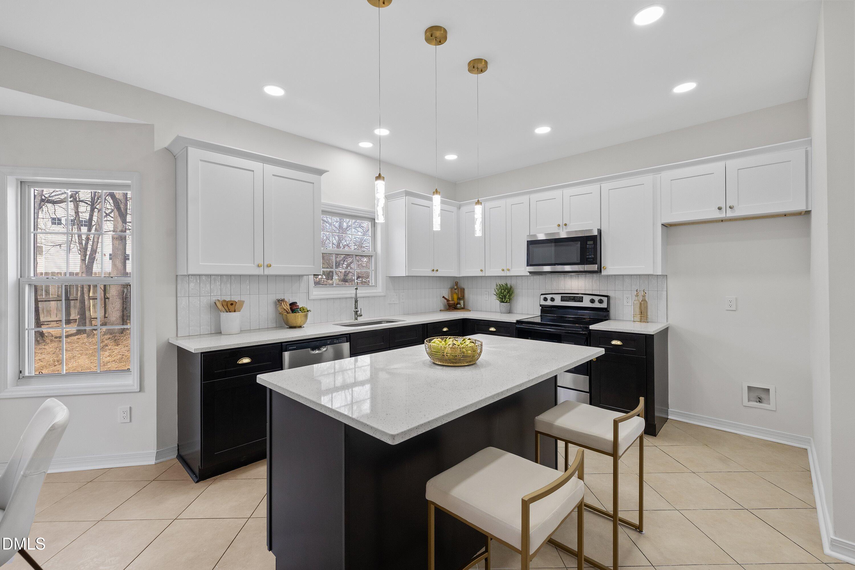 4219 Mantua Way Raleigh, NC 27604 - Photo 8 of 44 a kitchen with a sink a stove a refrigerator and white cabinets
