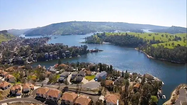 an aerial view of ocean and residential houses with outdoor space