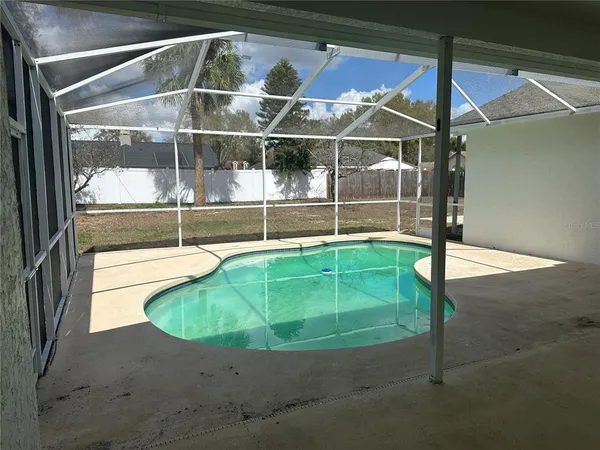 a view of a house with backyard and a tree